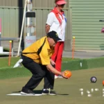 Bowler on the green getting ready to release bowl.