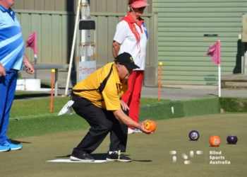 Bowler on the green getting ready to release bowl.
