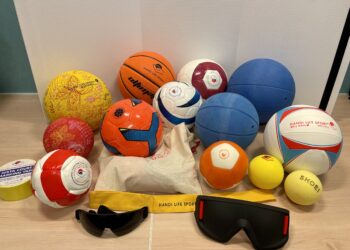 Image of a range of audible Blind Sports Balls, eye shades and running tethers on a table.