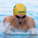 Swimmer wearing an Australian cap, swimming in the pool.