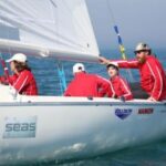 image of 4 people in a yacht, sailing in the harbour.