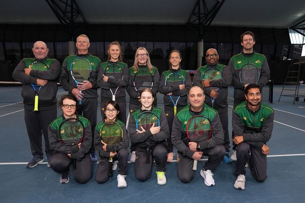 Pictured are members of the BLV Tennis team in their Tennis Australia uniforms for the World Blind Games, standing in front of tennis net.